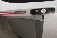 The rear with charge port behind the number plate, a parking sensor and backup camera. The black "knob" holds the light for the number plate.